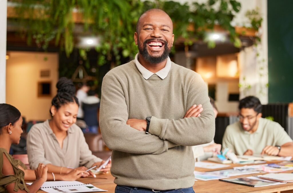 black man portrait smile and arms crossed in leadership for meeting teamwork or brainstorming at Coaching Business Maroc