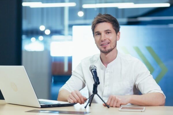 Business coach in office records online book, portrait looks at camera smiling