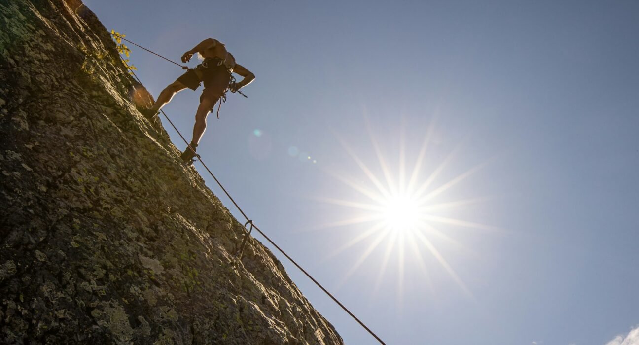 a man climbing up the side of a mountain